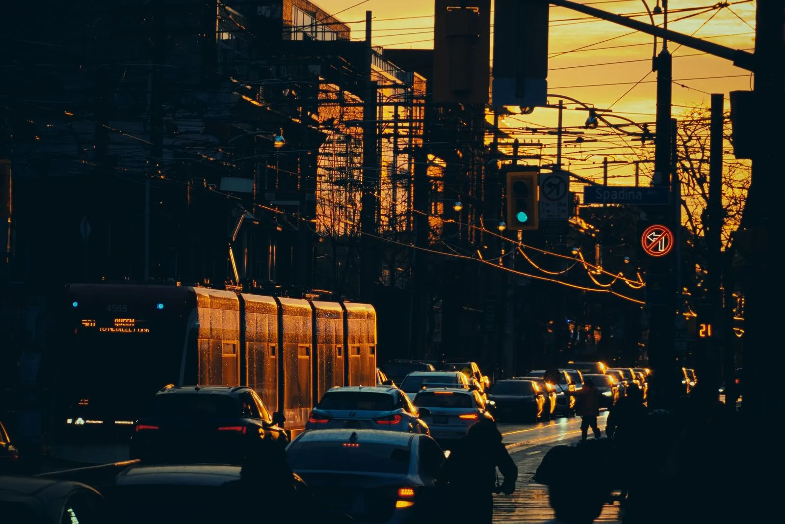 Sunset view of bustling Toronto street with traffic and trams.